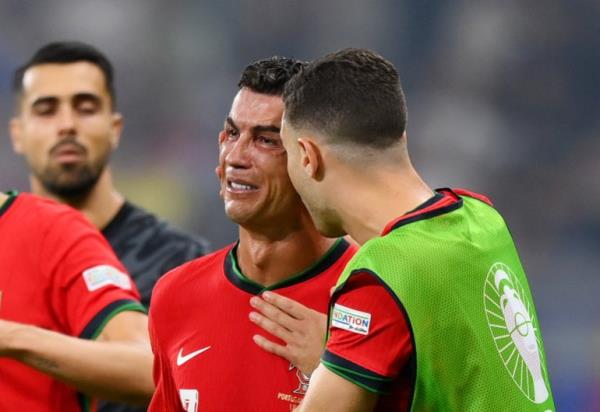 FRANKFURT AM MAIN, GERMANY - JULY 01: Cristiano Ro<em></em>naldo of Portugal looks dejected as he is co<em></em>nsoled by teammates ahead of the second half of extra-time during the UEFA EURO 2024 round of 16 match between Portugal and Slovenia at Frankfurt Arena on July 01, 2024 in Frankfurt am Main, Germany. (Photo by Justin Setterfield/Getty Images)